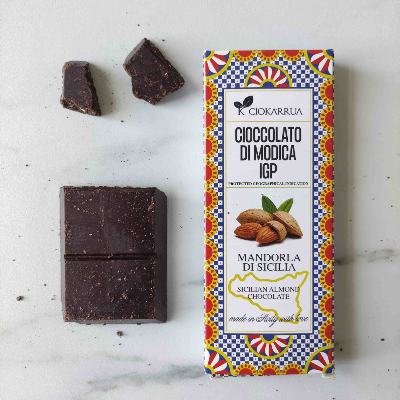 Un chocolat noir brut et croustillant, fabriquée à froid, texture granuleuse, éclats d’amandes locales